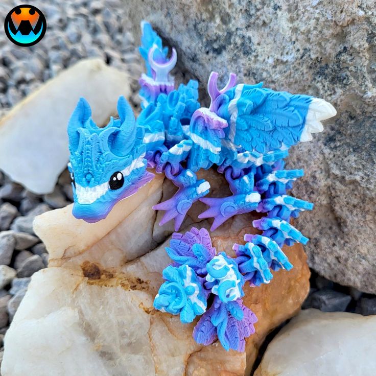 a small blue and white toy sitting on top of a rock