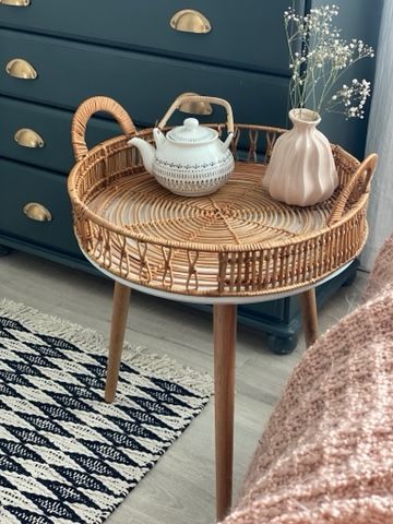 a wicker tray with a teapot on it in front of a blue dresser