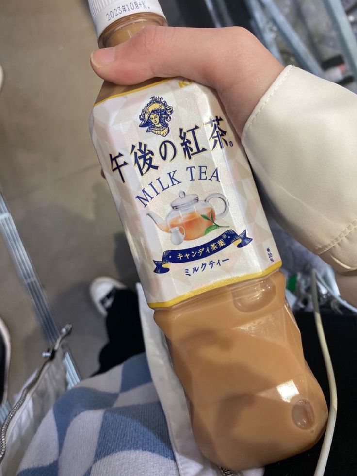 a person holding a bottle of milk tea