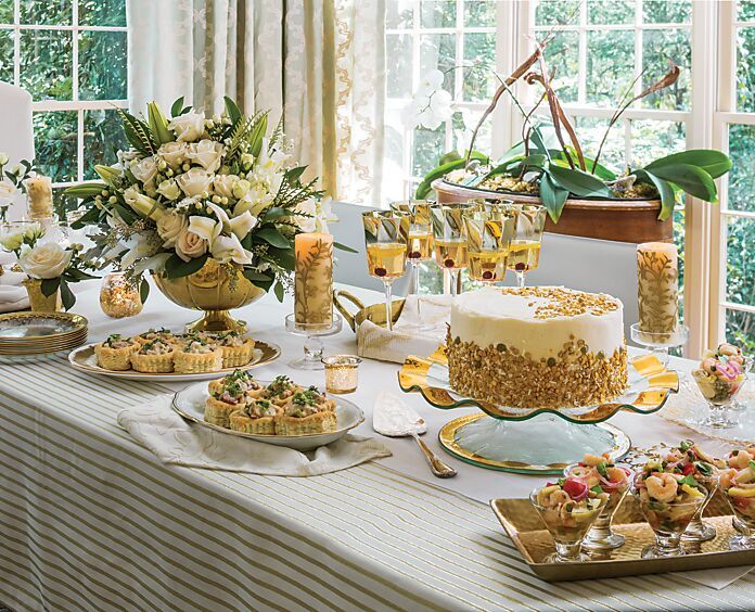 a table topped with cakes and desserts next to windows