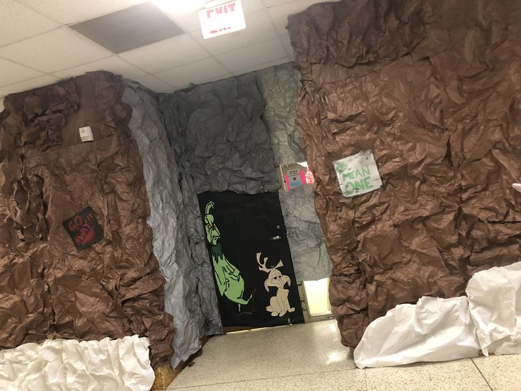 an office cubicle decorated with rock walls and paper mache art on the door