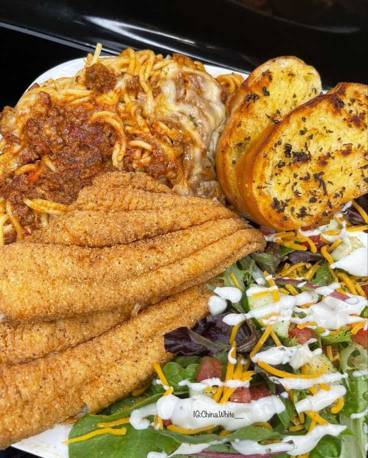 a white plate topped with different types of food next to a pile of fries and coleslaw