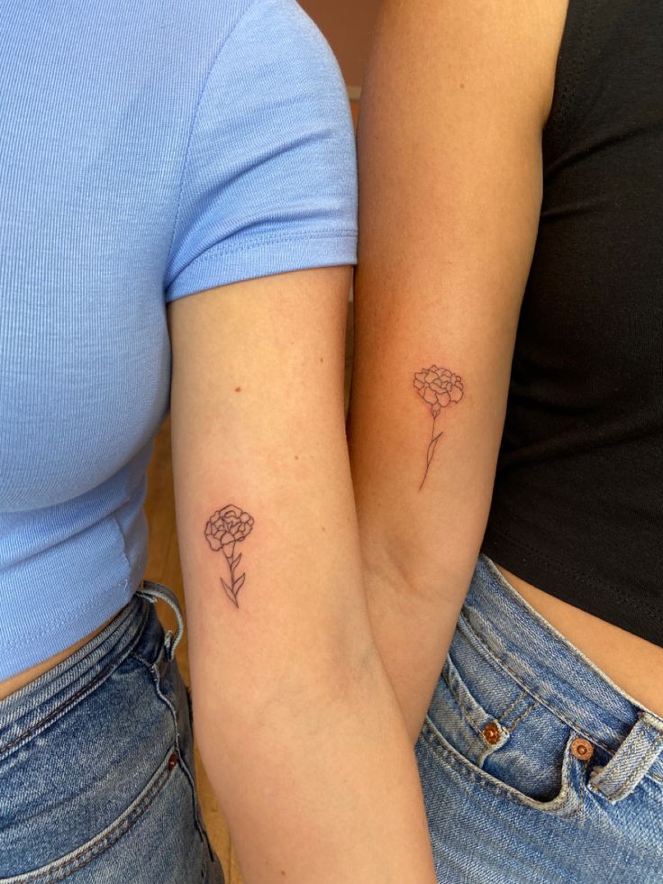 two women with matching tattoos on their arms