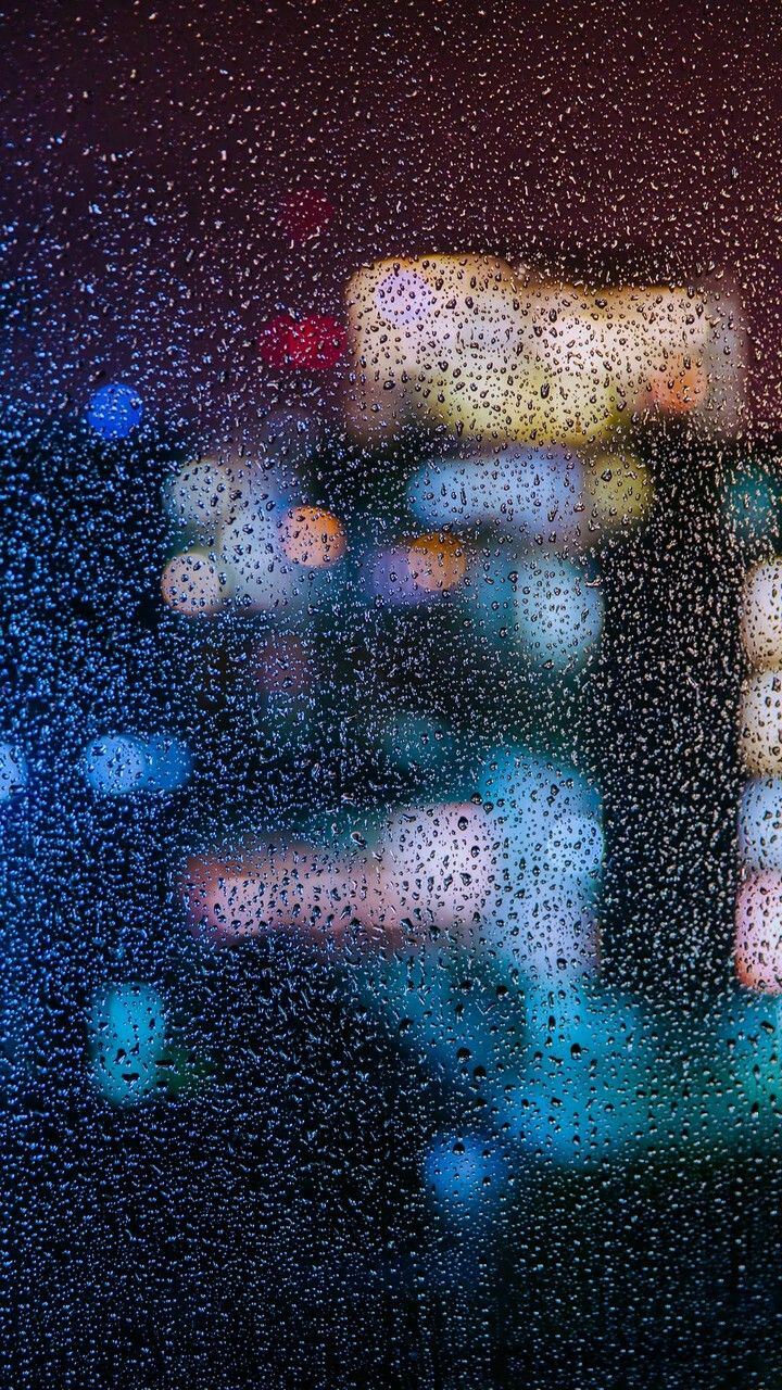 rain drops on the window as traffic passes by