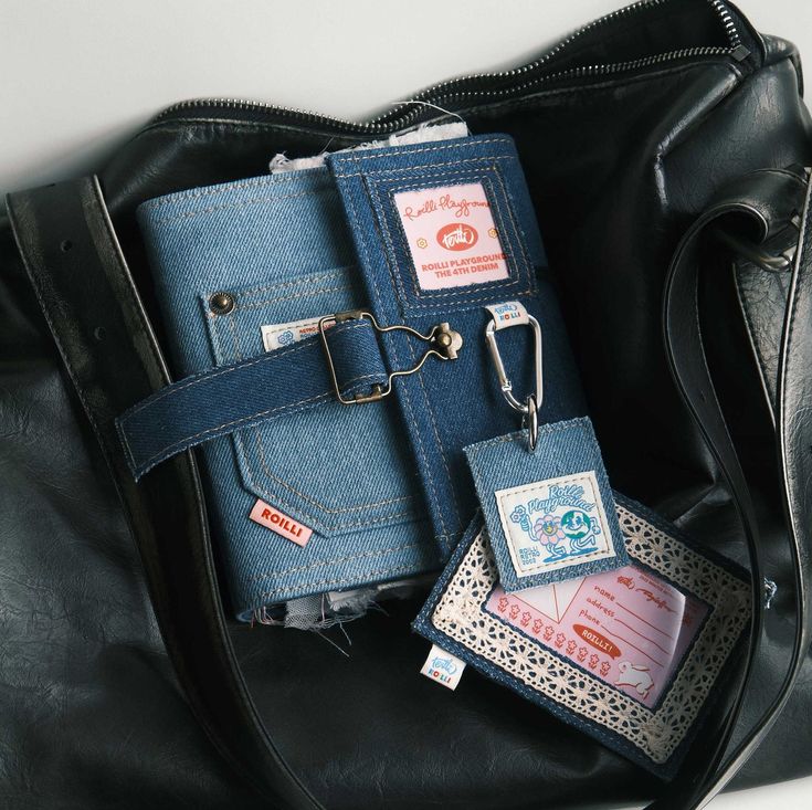 a black purse with two tags attached to it and some other items in the pocket