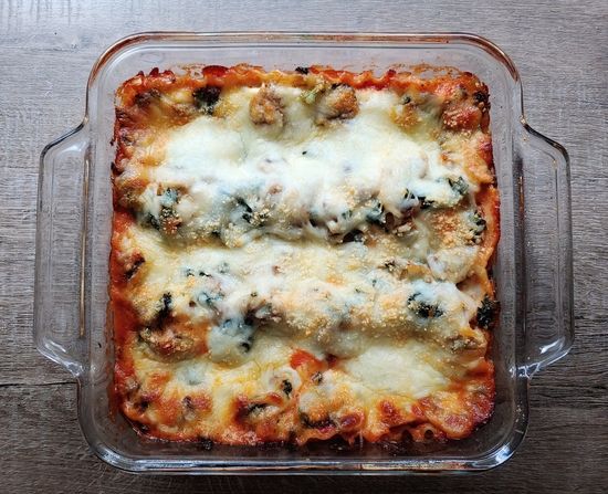 a casserole dish with meat and cheese in it on a wooden table top