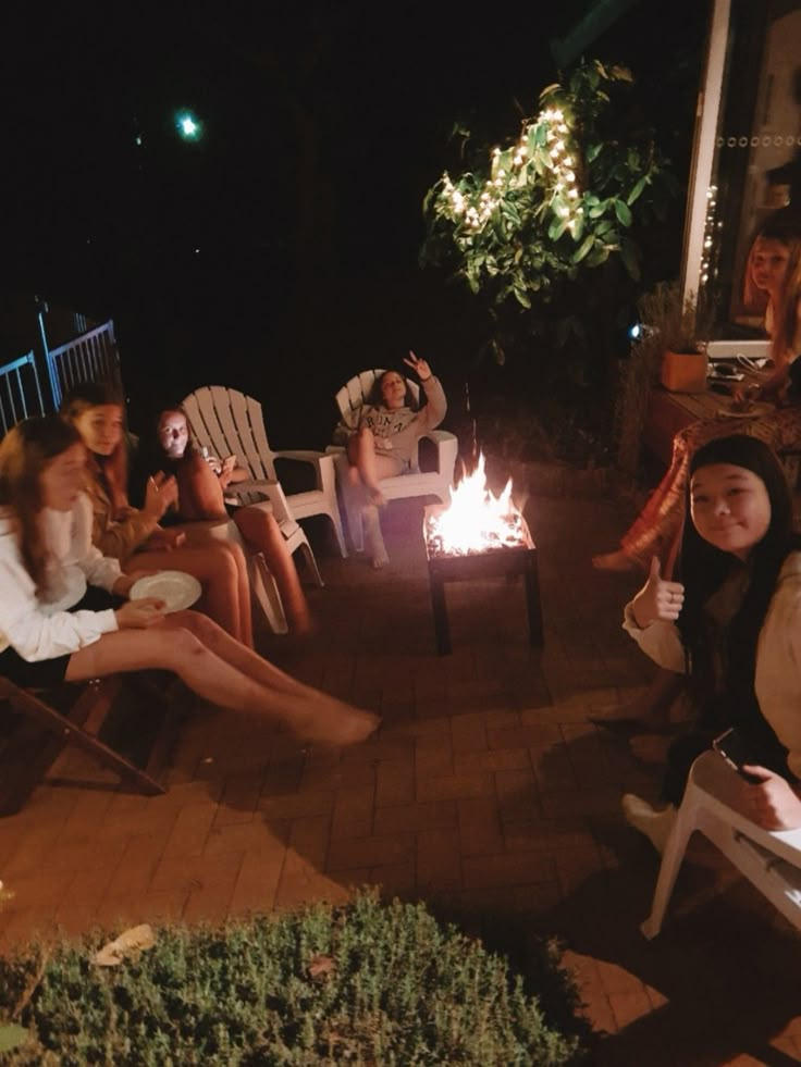 people sitting around a fire pit at night