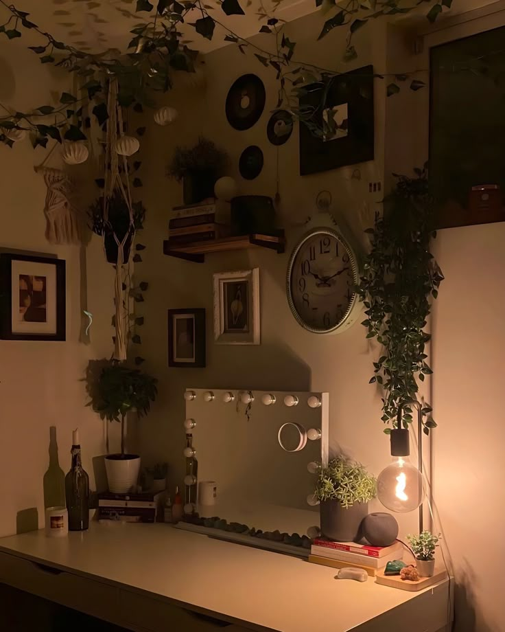 there is a desk with plants and pictures on the wall above it in this room