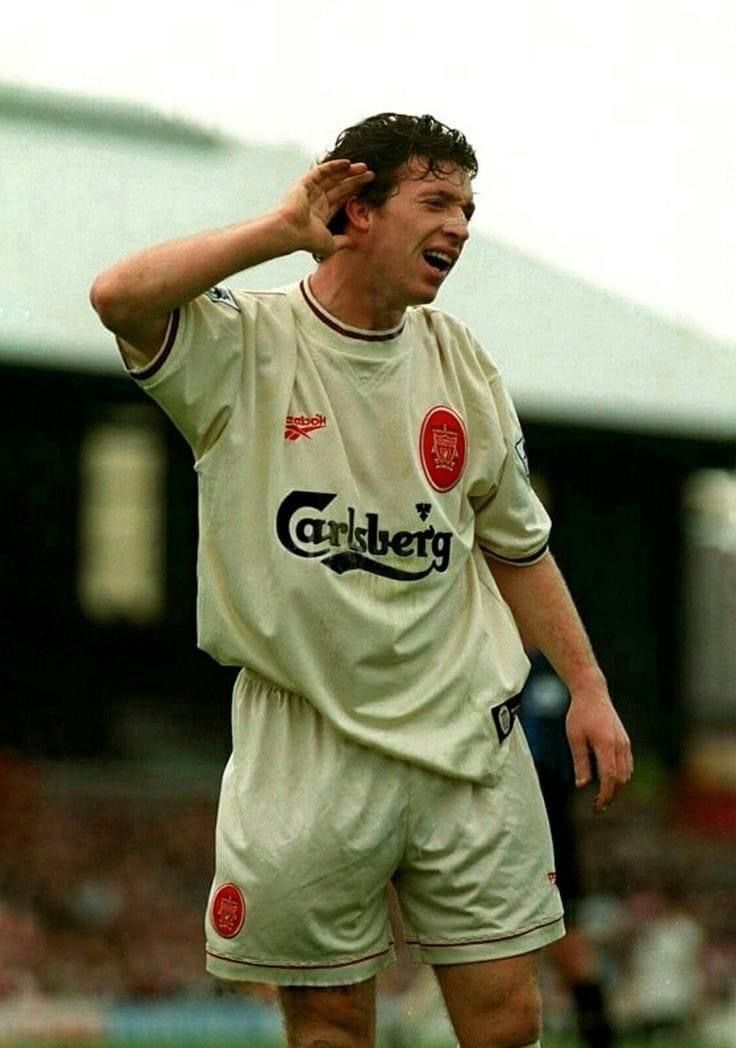 a soccer player holding his head while standing on the field