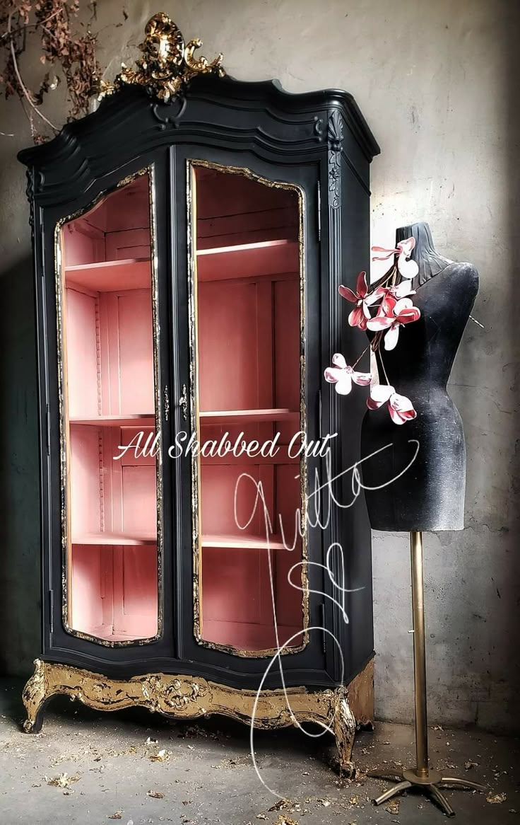 an old black china cabinet with pink glass doors