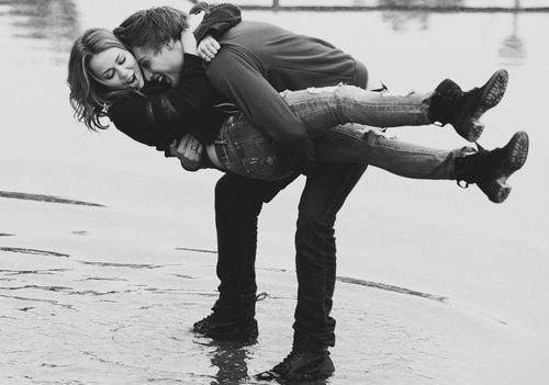 a man and woman are standing in the water with their arms around each other as they hug