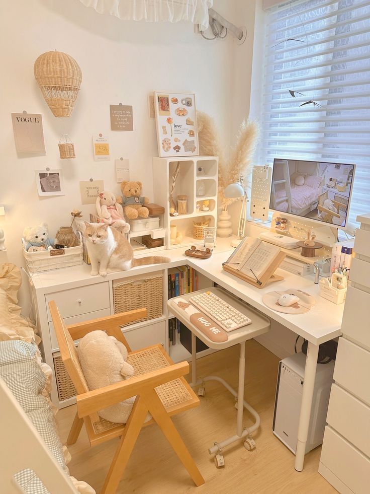 a white desk topped with a computer monitor next to a wooden chair near a window