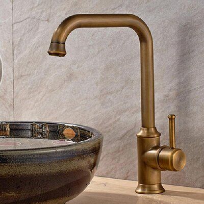 a faucet with water running from it in a bowl shaped sink next to a marble wall