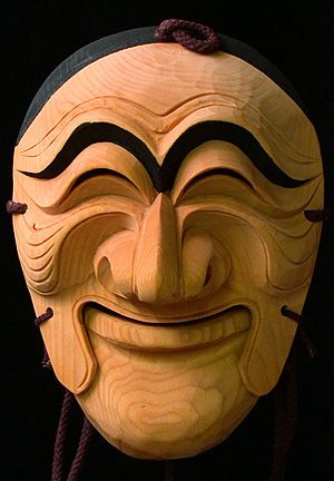 a wooden mask that has been carved to look like a man's face