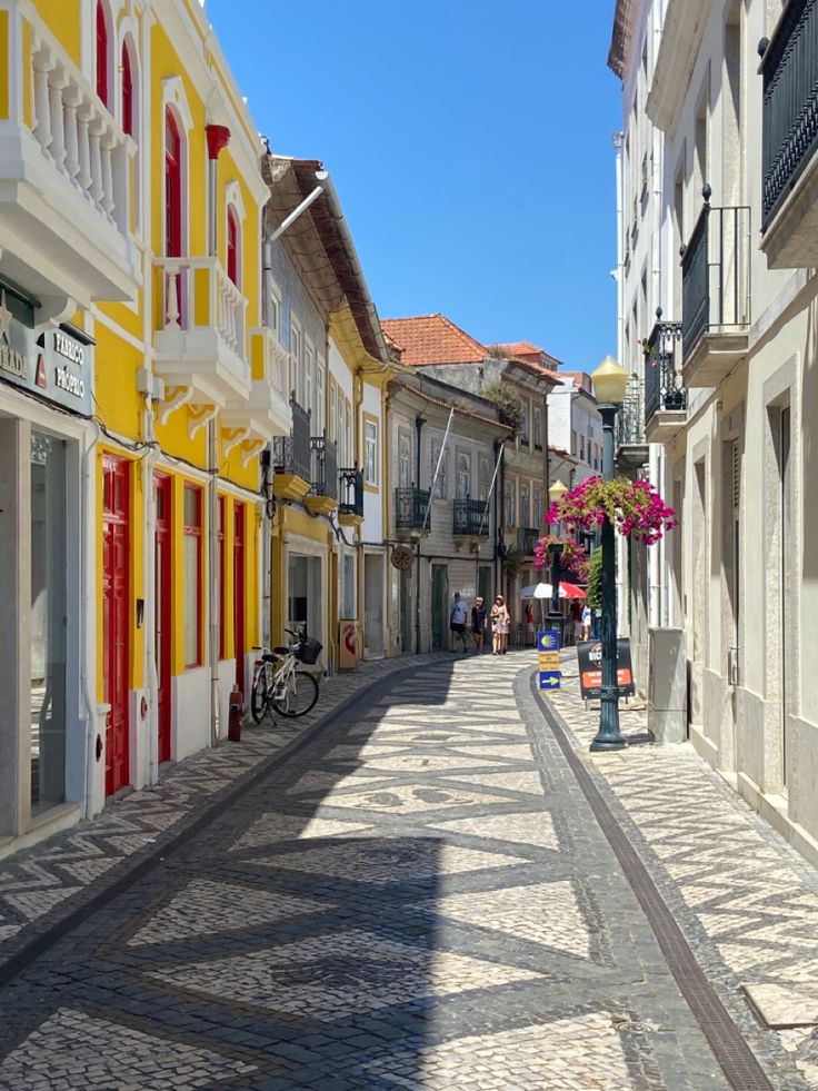 an empty street lined with colorful buildings and flowers