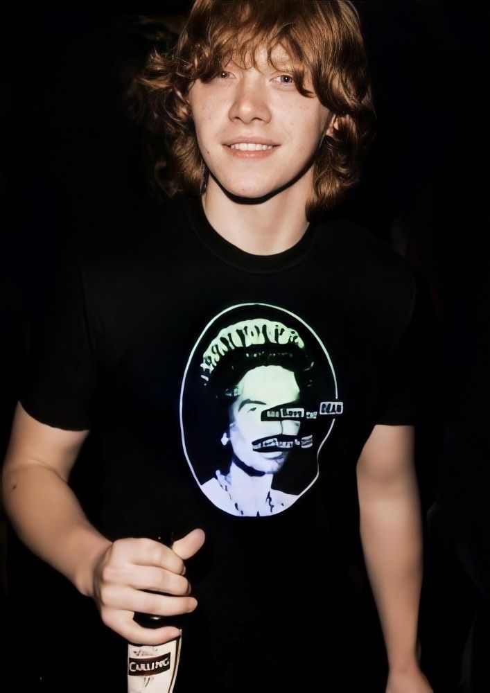 a young man with curly hair wearing a black shirt