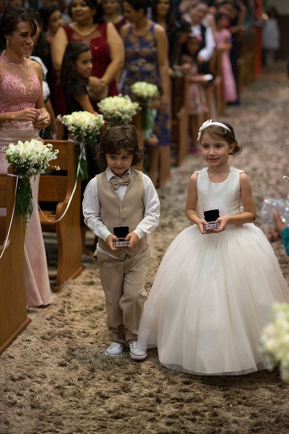 two young children dressed in formal wear standing next to each other at a wedding ceremony