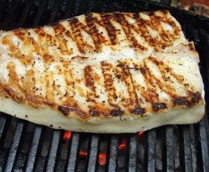 two pieces of meat cooking on top of a grill