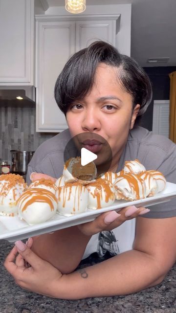 a woman is holding a tray with desserts in front of her face and making a funny face