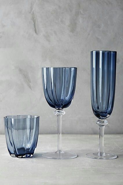 three blue glass goblets sitting next to each other on a white countertop