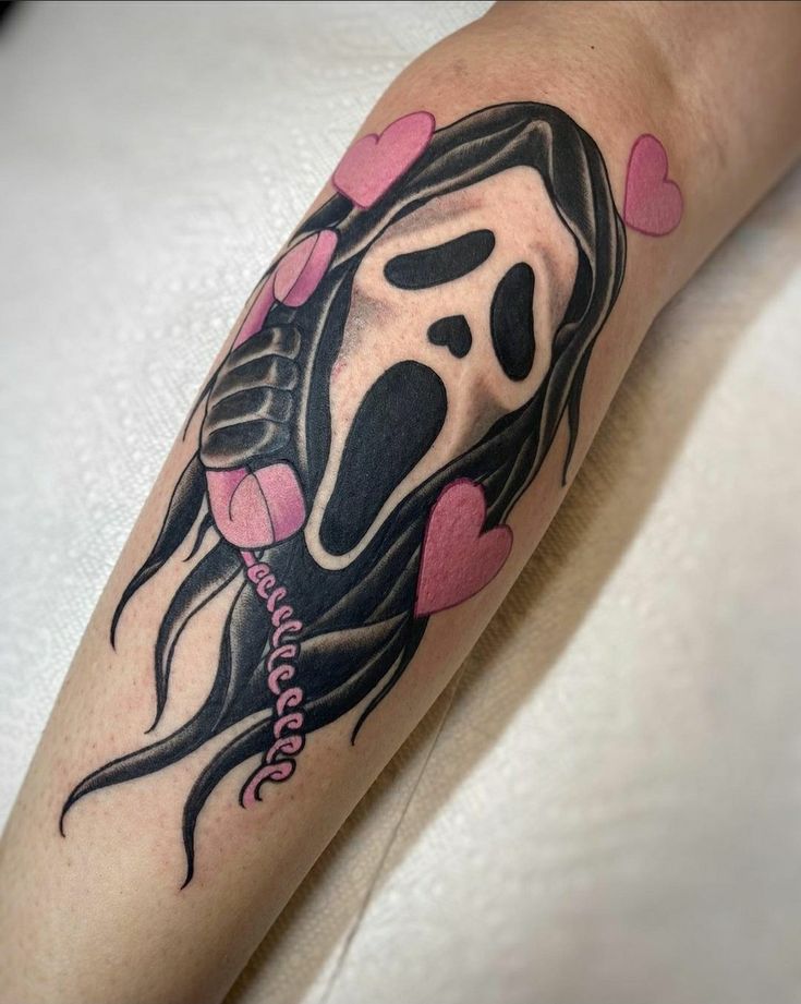 a woman's leg with a tattoo on it that has a black and pink design