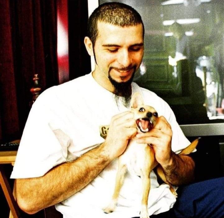 a man holding a small dog in his lap