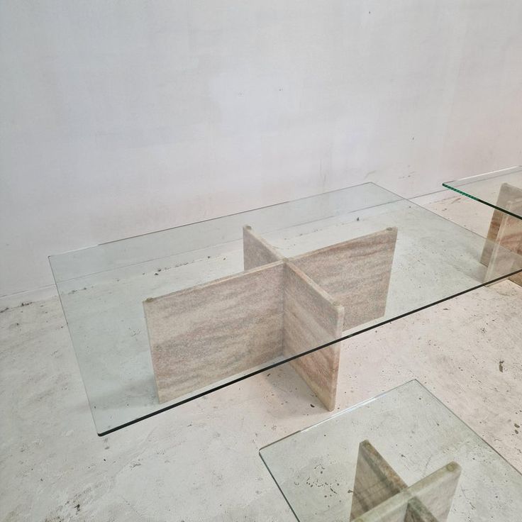 three glass tables sitting on top of each other in front of a white wall and floor