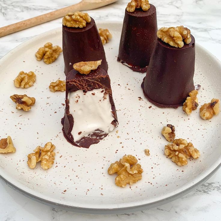 three desserts on a white plate with walnuts