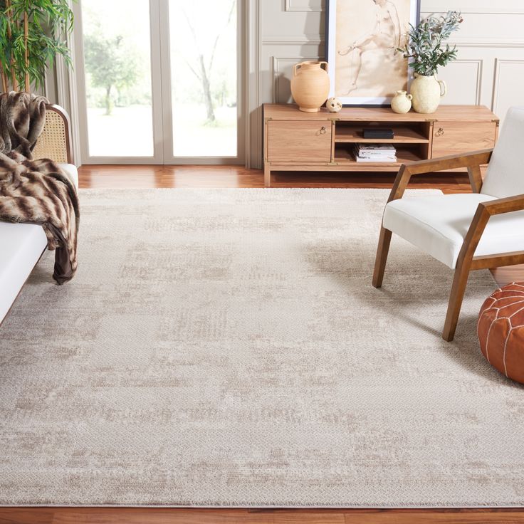 a living room area with a couch, chair and rug