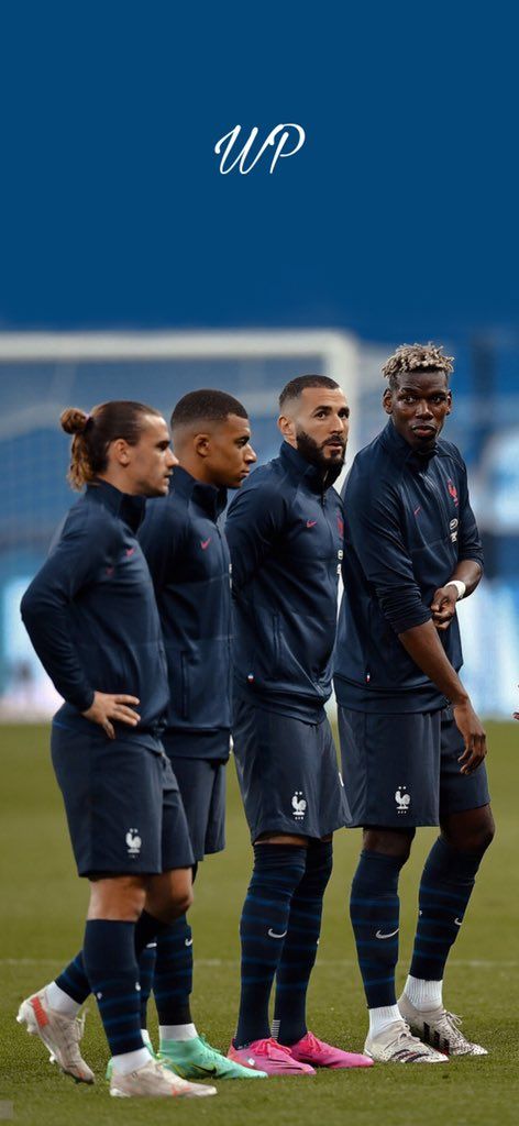 several soccer players are standing on the field with their hands in their pockets and looking at each other