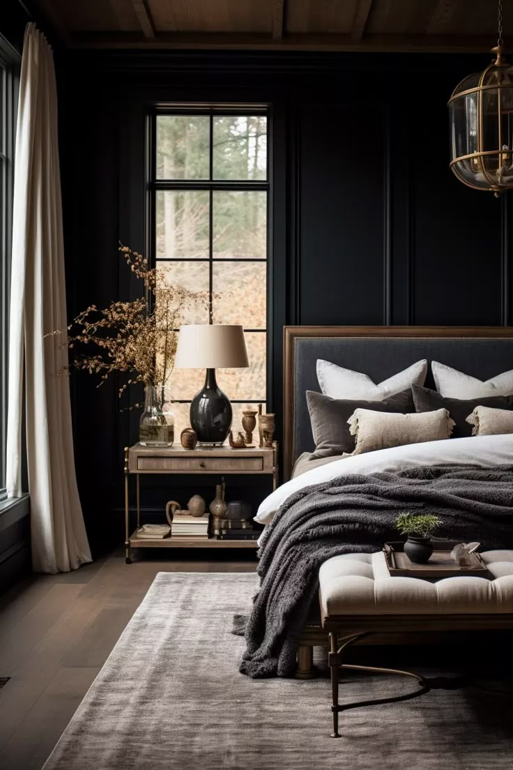 a bedroom with black walls and white bedding in front of a large window that looks out onto the woods