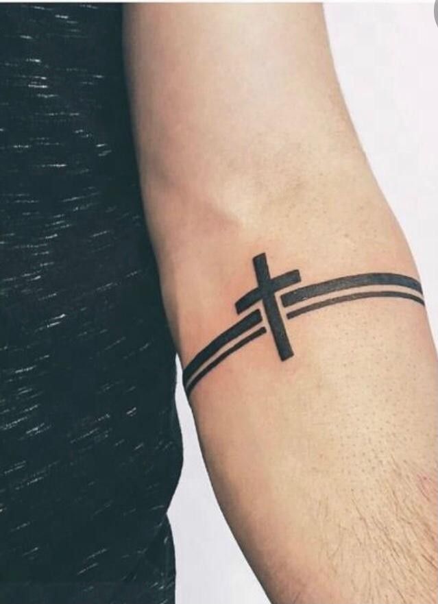 a man with a cross tattoo on his arm