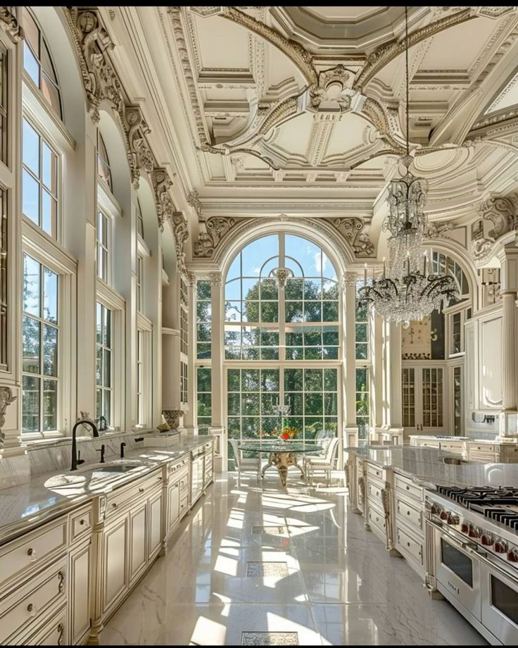 a large kitchen with marble counter tops and white cabinets, along with an arched window