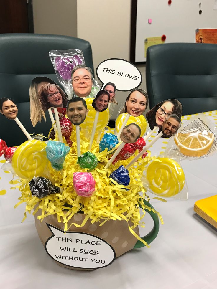 an arrangement of lollipops in a coffee cup with faces on the sides