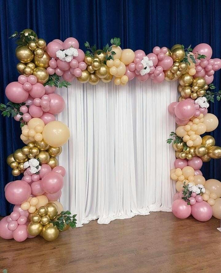 the balloon arch is decorated with gold, pink and white balloons