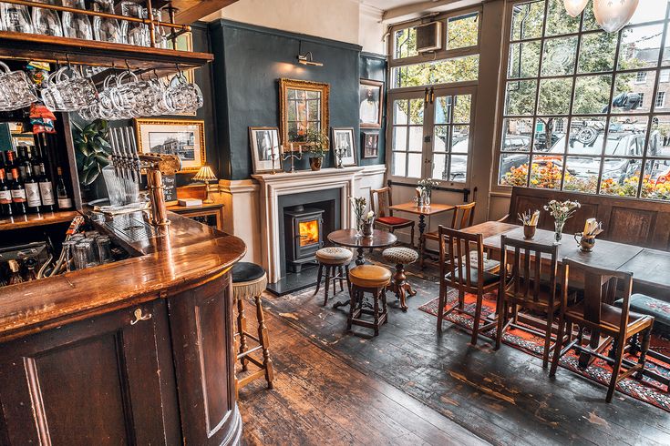 the interior of a restaurant with wooden tables and bar stools in front of large windows