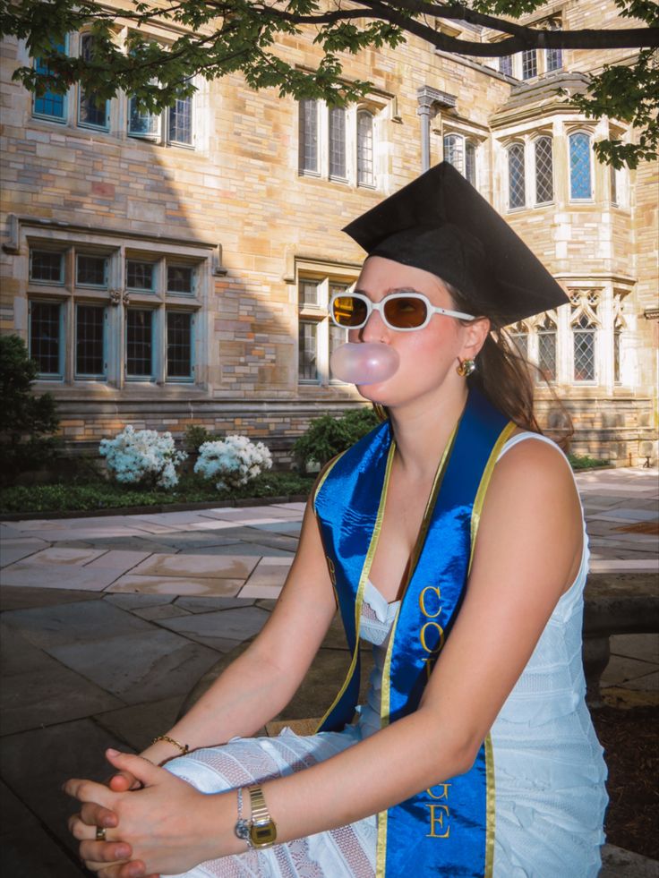 a woman in a graduation gown blowing bubbles