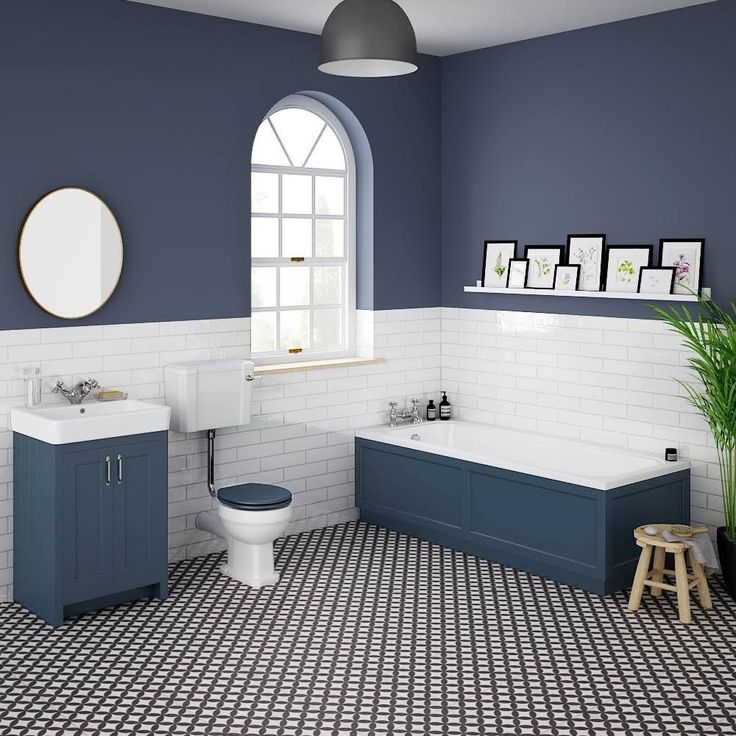 a blue and white bathroom with black and white floor tiles on the walls, toilet, sink and tub