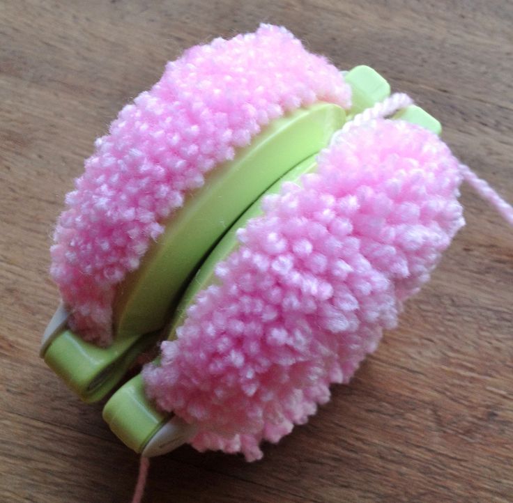 a close up of a toy on a table with a string attached to the head