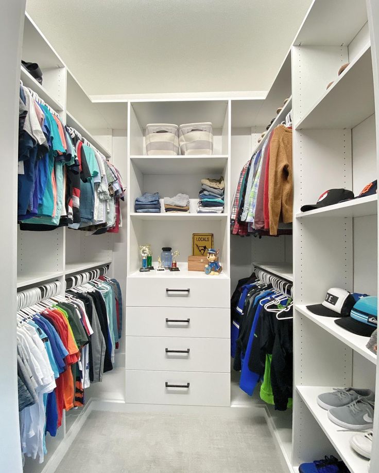 a white closet filled with lots of clothes and other items on shelves next to each other