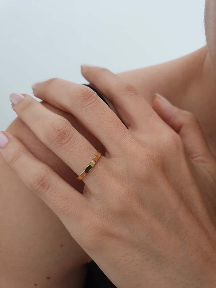 a woman's hand with a gold ring on it