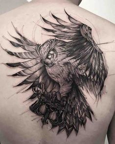 a man's back with an owl tattoo on it