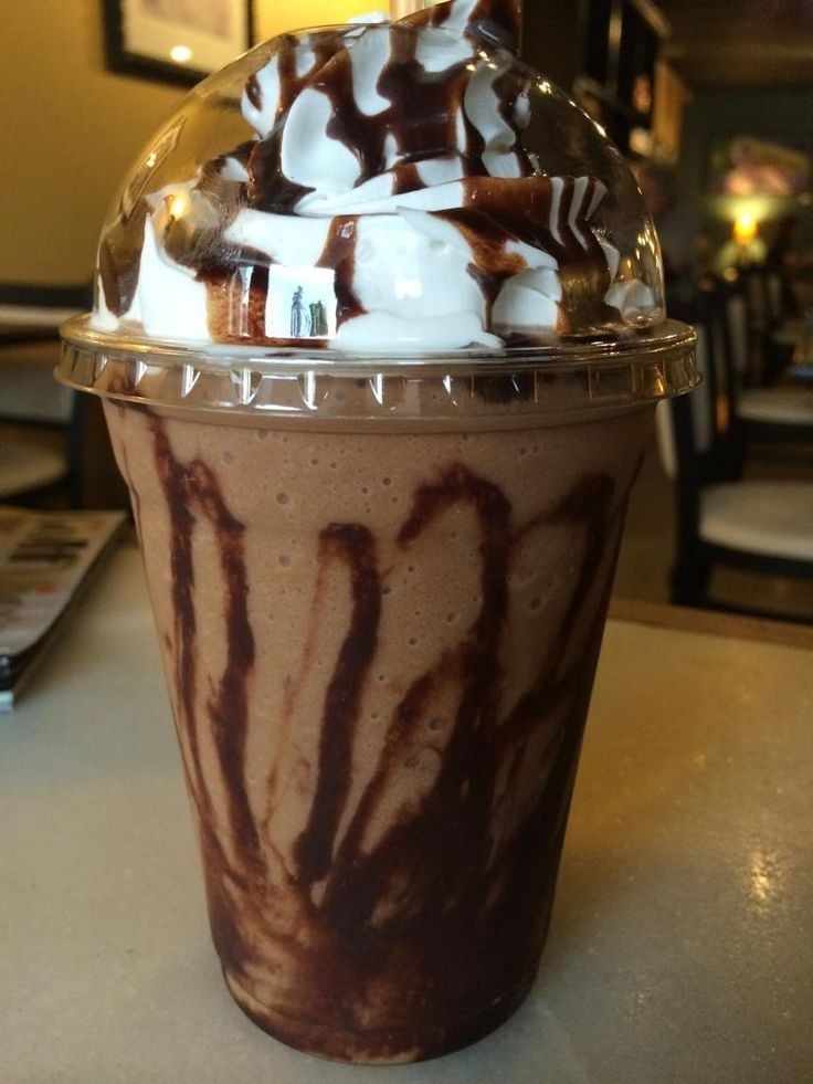 there is a chocolate milkshake with whipped cream on top and drizzled in chocolate