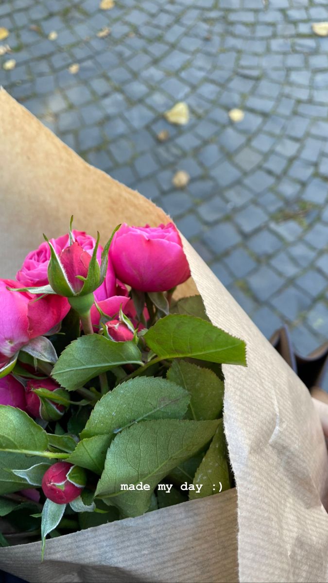 a bouquet of pink roses is wrapped in brown paper