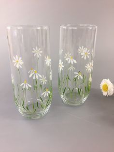 two glass vases with daisies painted on them