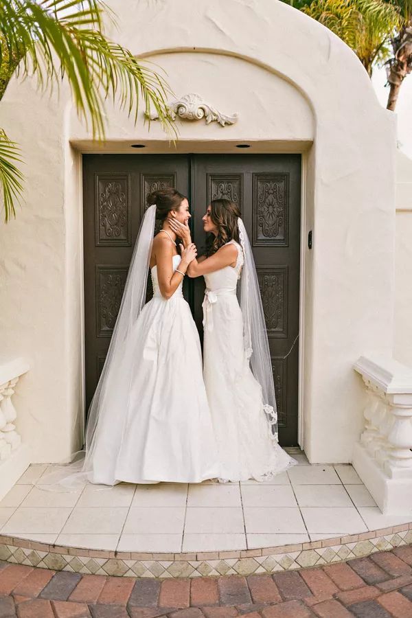 two brides standing in front of a door