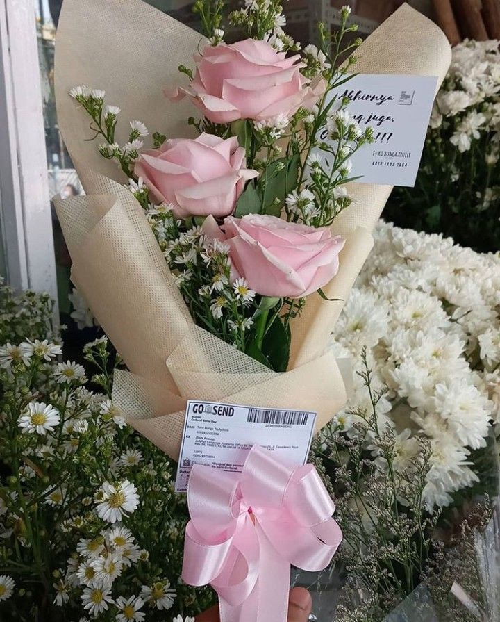 a bouquet of pink roses is held by someone's hand with a price tag on it