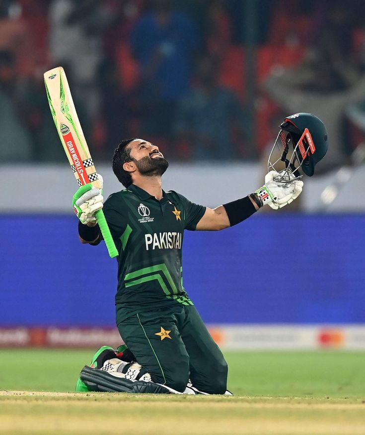 the pakistan cricket player is sitting on the ground and holding his bat in one hand