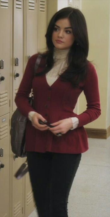 a woman standing in front of lockers with her hand on her hip and looking at the camera