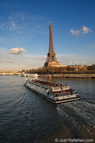 a boat is traveling down the river in front of the eiffel tower